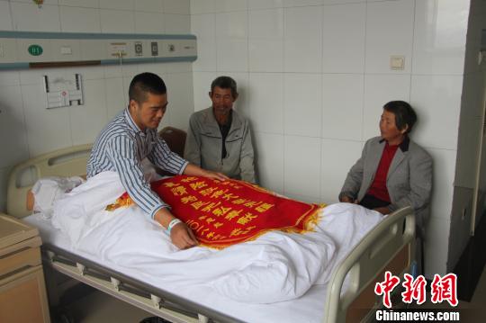 被救的李忠起、張總鳳夫婦看望受傷后的李運(yùn)飛?！⊥粲?攝