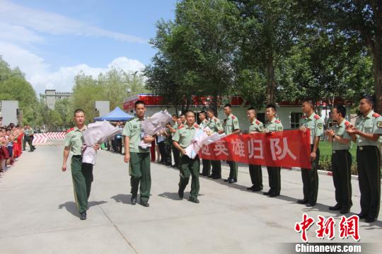 部隊(duì)官兵們迎接出院歸來的李運(yùn)飛(中)和其他消防戰(zhàn)士。　汪渝 攝