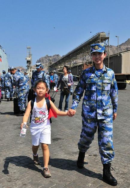 2015年3月，也門，海軍女戰(zhàn)士牽著一名小女孩的手準備登上軍艦。