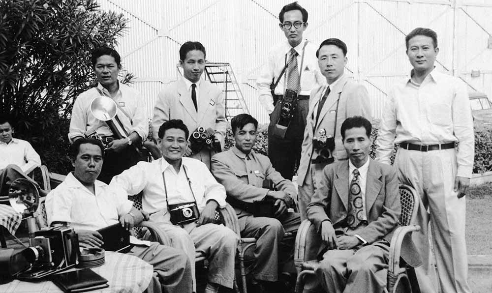 新華社記者錢嗣杰（站立者右二）在采訪會議開幕式后和外國記者在會場外休息。