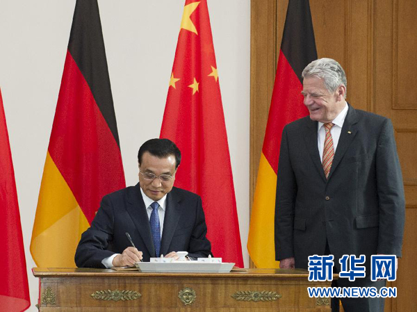 10月10日，國務(wù)院總理李克強在柏林會見德國總統(tǒng)高克。這是李克強總理在高克總統(tǒng)的陪同下在貴賓簿上簽字。 新華社記者 王曄 攝 