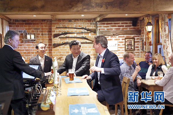 這是會晤結(jié)束后，習(xí)近平在卡梅倫陪同下乘車前往當(dāng)?shù)匦℃?zhèn)體驗(yàn)酒吧文化。新華社記者 鞠鵬 攝